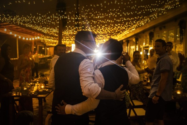 Pareja de recién casados abrazados en un ambiente romántico bajo guirnaldas de luces verbena en la terraza de DBlanc.