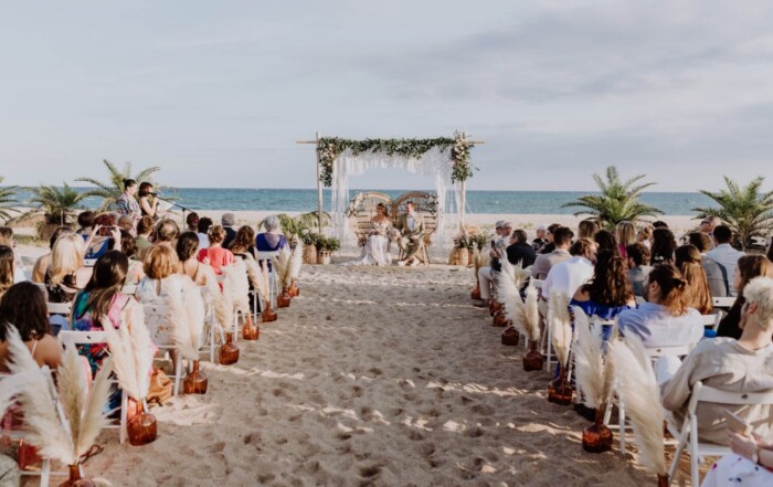 Casament reial a la platja privada de DBlanc amb convidats asseguts davant del mar a Catalunya
